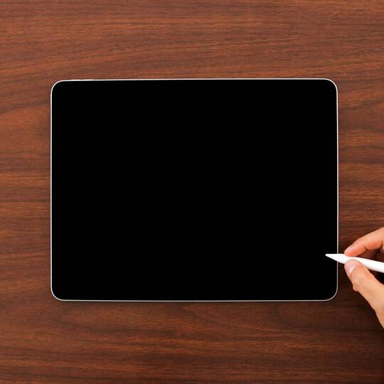 Hand hält Apple Pencil über ausgeschaltetem iPad