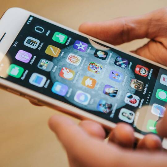 Person tippt auf weißem iPhone