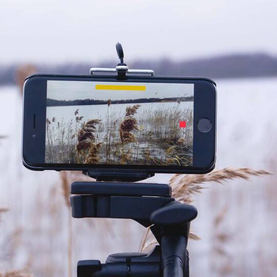 Laufende Videoaufnahme von einem Seeufer auf einem iPhone auf Stativ