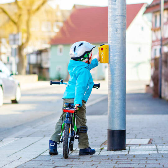 Kind auf Weg zur Schule hält an Ampel