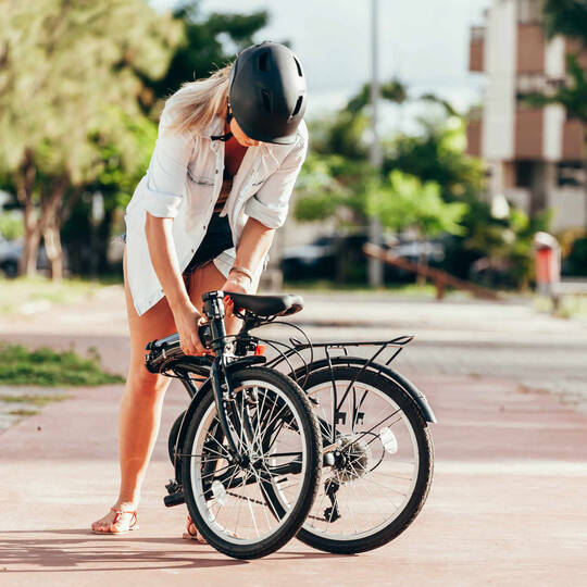 Frau klappt ihr Fahrrad ein