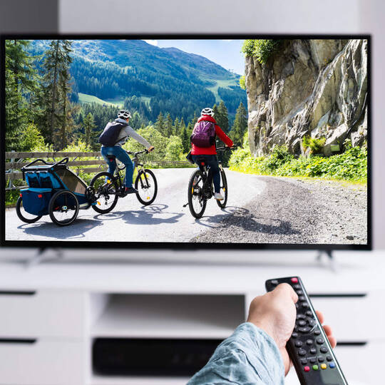 Person schaut Videos auf dem Fernseher