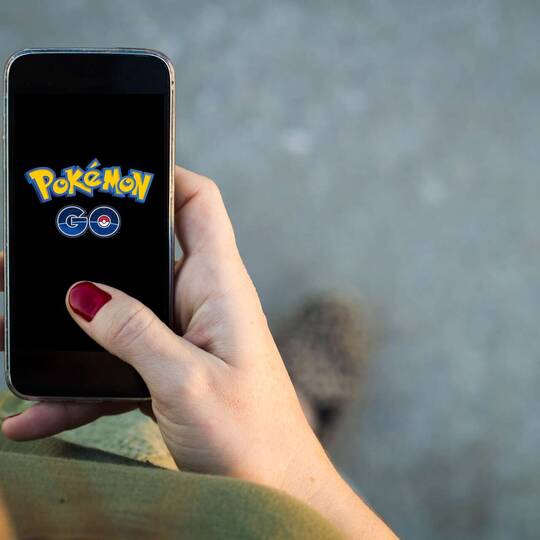 Person hält Handy in der Hand, auf welchem Pokémon Go startet