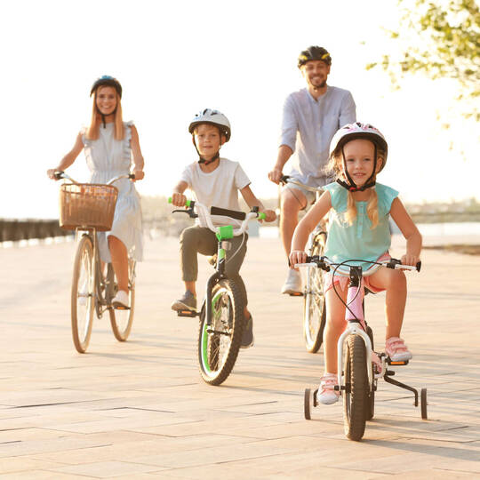 Eltern fahren mit ihren Kindern Fahrrad