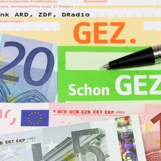 Rundfunkbeitrag und Geldscheine liegen auf dem Tisch