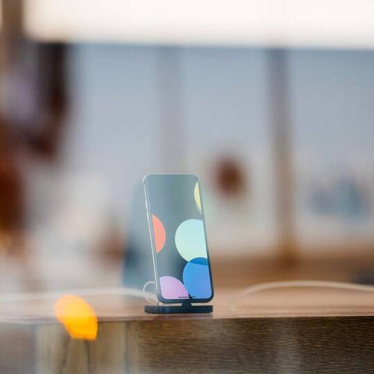 ein Smartphone steht auf einem Tisch auf einer Dockingstation