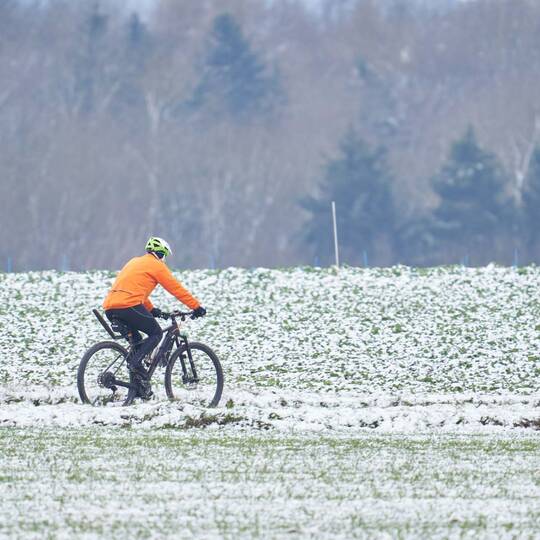 Fahrradfahrer fährt im Schnee