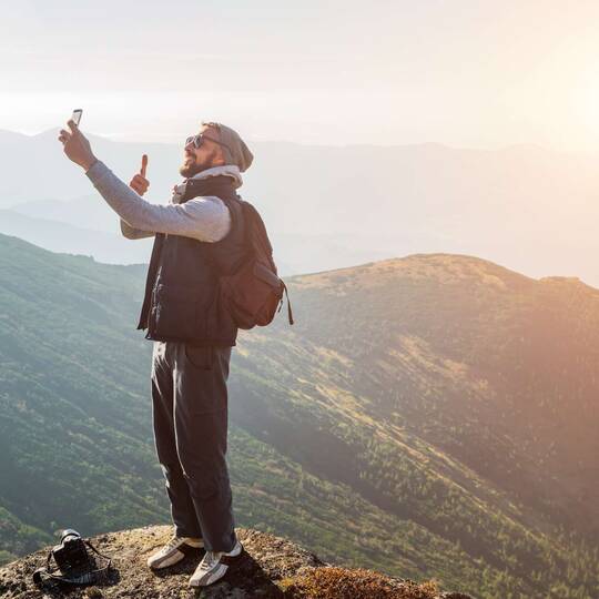 eine Person macht ein Selfie auf einem Berg