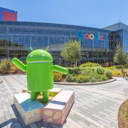 Android-Maskottchen vor einem Google-Gebäude mit Glasfront