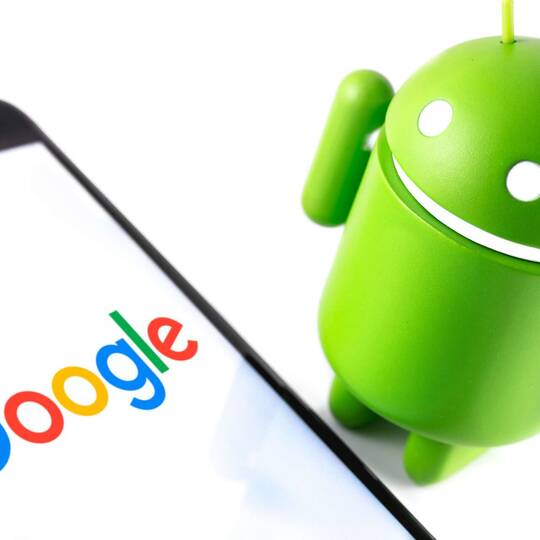 ein Smartphone zeigt das Google Logo und das Android Logo steht daneben
