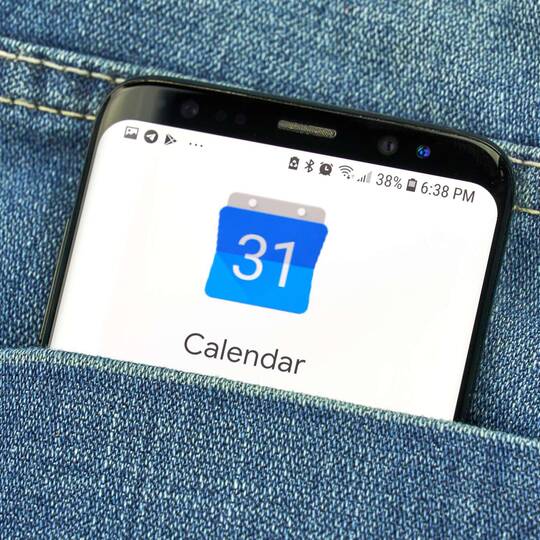 Smartphone mit Google Kalender auf dem Bildschirm in einer Hosentasche