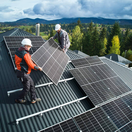 Handwerker installieren eine Solaranlage auf einem Dach