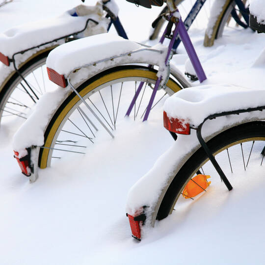 Drei verschneite Fahrräder