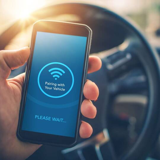 Person verbindet Handy über Bluetooth mit dem Auto