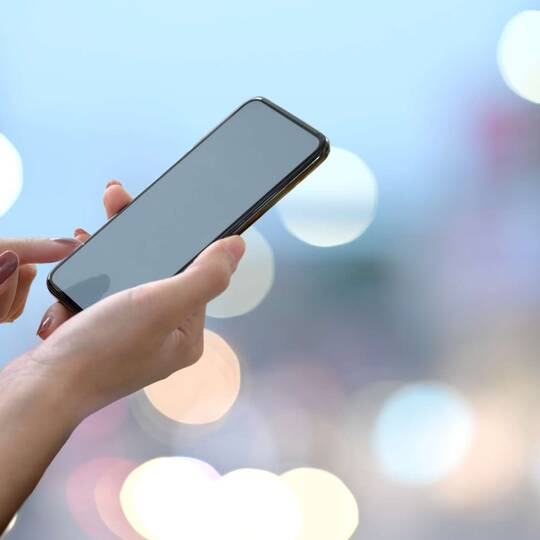 Person hält Smartphone in der Luft