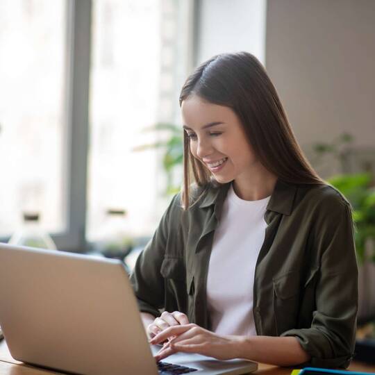 Frau sitzt an Laptop im Home Office