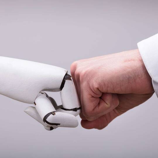 Roboter und Mensch geben sich die Faust