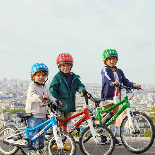 Drei Kinder auf Fahrrädern mit Helmen